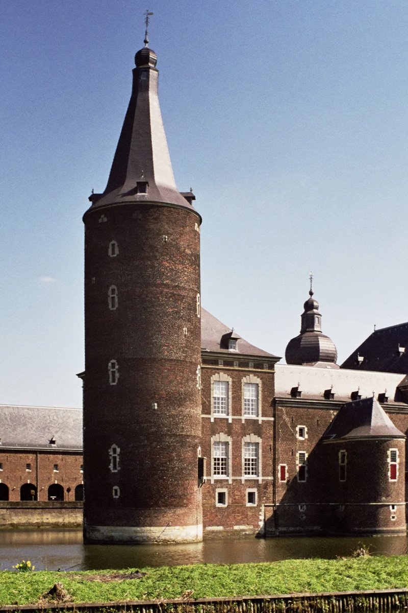 Hoensbroek Castle's brick towers reflected in its moat in Zuid-Limburg, Netherlands